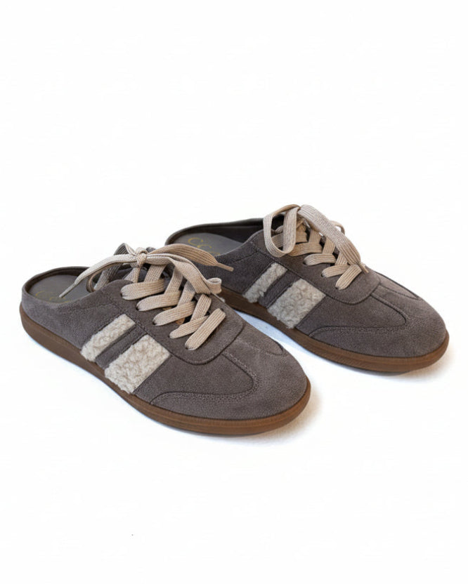 Pair of brown sneakers with white laces on a white background